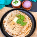 Mixed veg paneer and edamame paratha served with butter and with yogurt and onion.