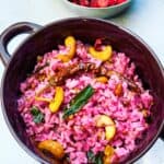 Cranberry rice with cashews on top and cranberries in the background.