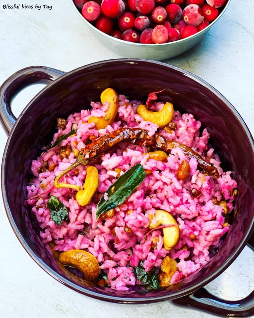 Cranberry rice with cashews on top and cranberries in the background.