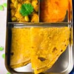 Carrot chapati, potato edamame curry and persimmon hearts in lunchbox.