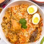 Chicken Biryani with chicken drumsticks and eggs on top.
