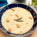 Quinoa pongal with cashews and curry leaves on top.