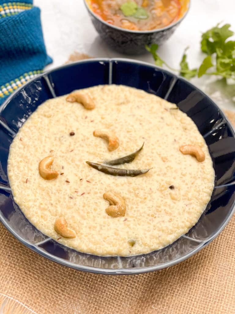 Quinoa pongal with cashews and curry leaves on top.