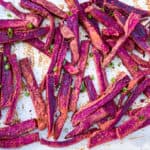 Baked purple sweet potato fries on parchment paper.