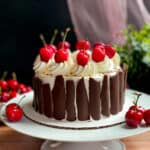 Quinoa black forest cake with chocolate bark and cherries as decorations.