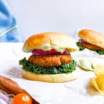 Tandoori tofu burgers with chips and tomatoes on the side.