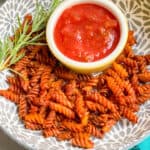 Air fryer pasta chips in a bowl and salsa dip in a bowl.