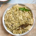 Mint pulao in a bowl with mint leaves as garnish.